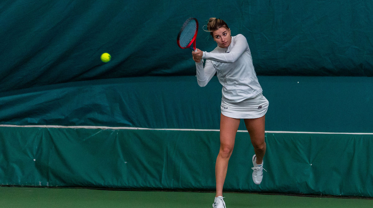 Photo of Giulia Martins-Cavalcante ’26 hitting a ball with a tennis racket.