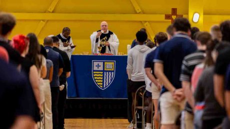 Picture of Fr. Raymond Dlugos, O.S.A., delivering Mass of the Holy Spirit in front of a crowd of Merrimack students.