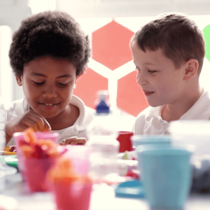 Two children eating snacks together.