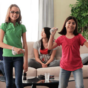 Two children smiling whiling playing an interactive video game.