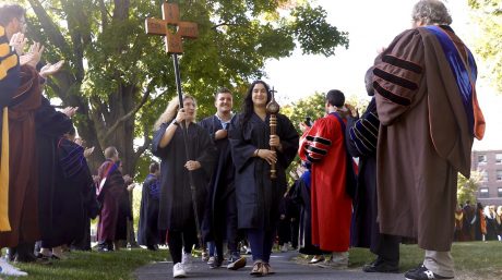 Photo of three Merrimack seniors leading the student procession at Academic Convocation.